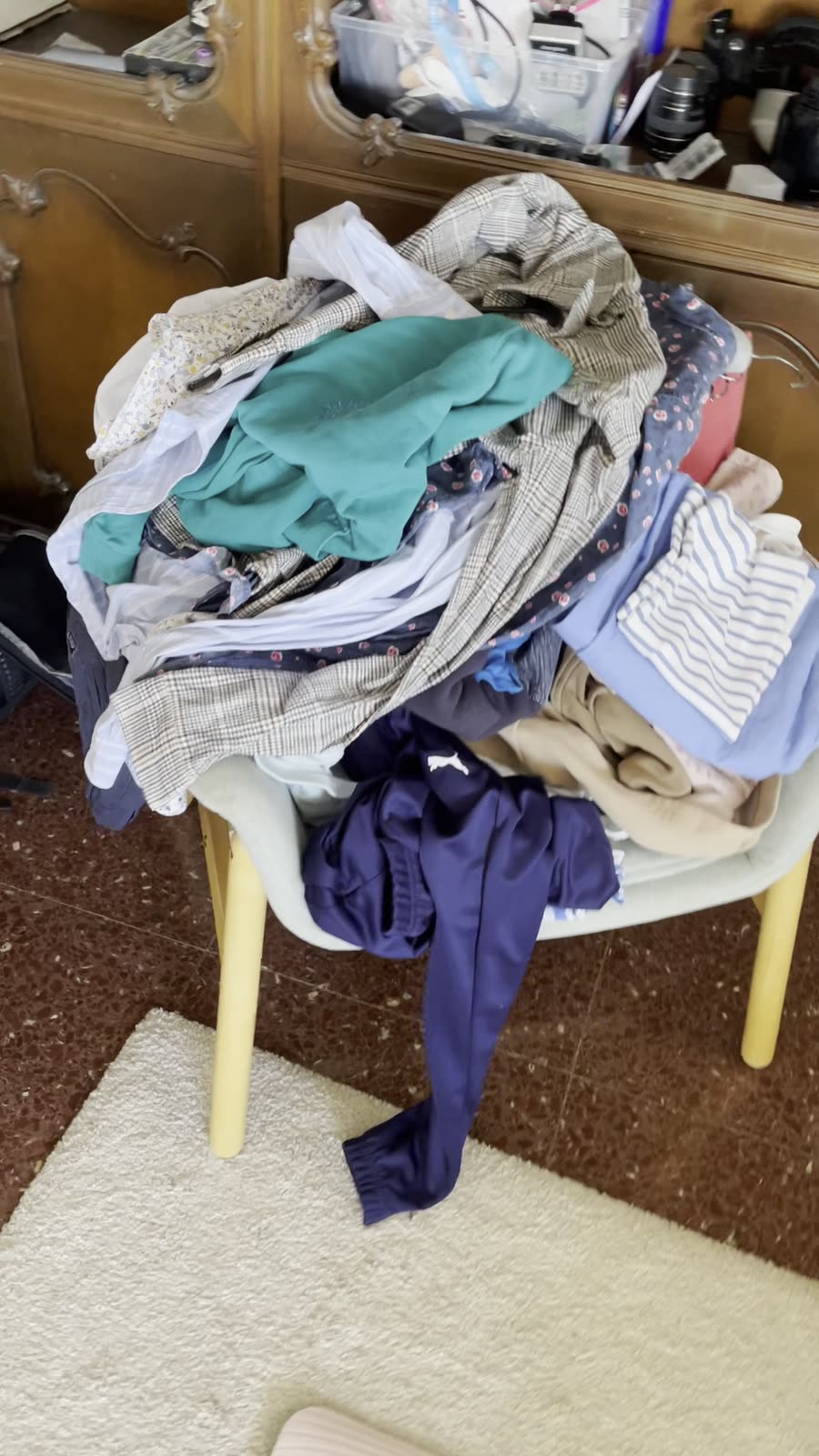 A chair piled high with unlisted second-hand clothes